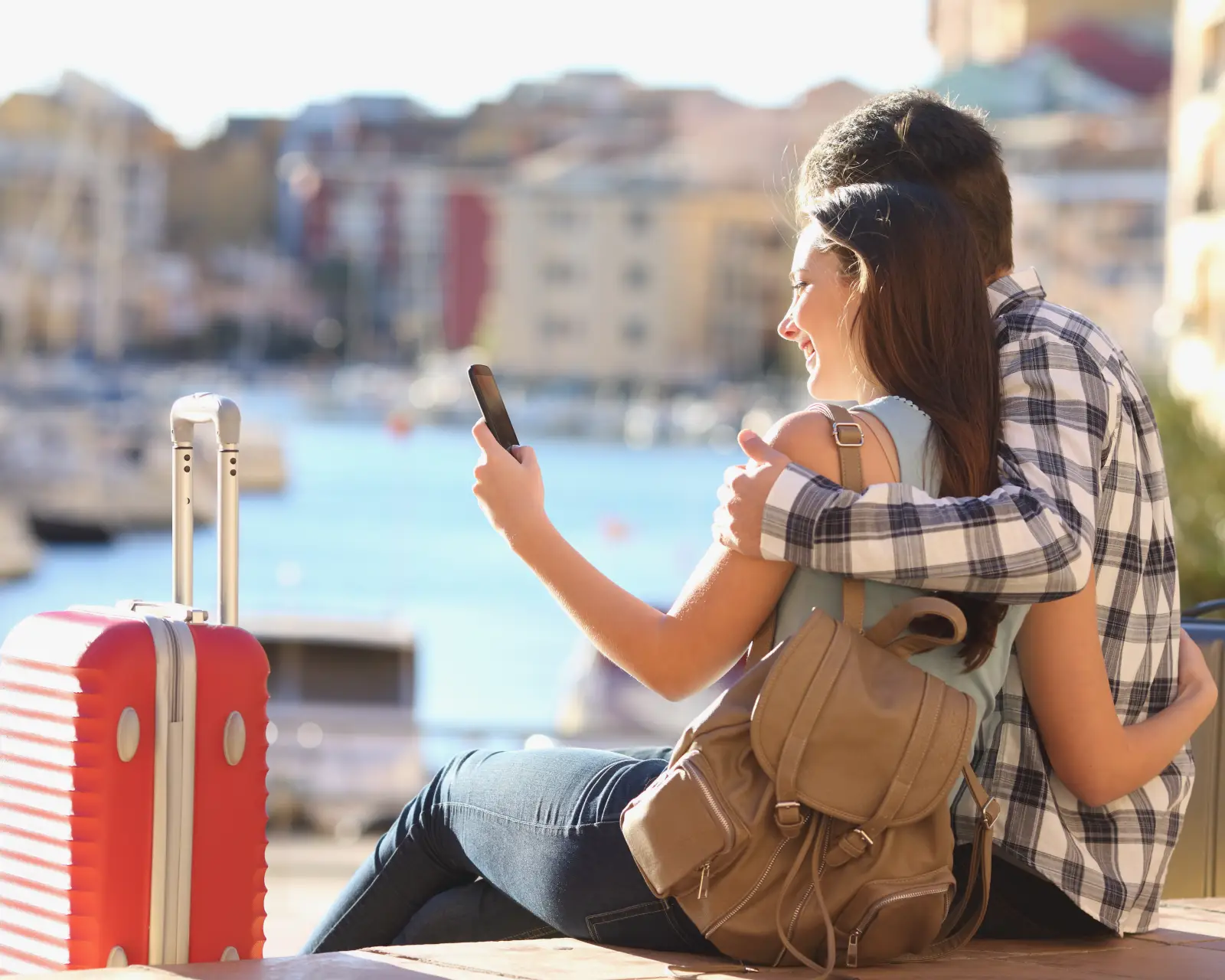 Tourist couple searching on phone by a harbour
